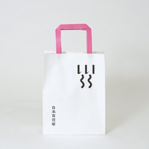 シンプルな縦留めのハンドルを採用した、食と雑貨のセレクトショップのオリジナル紙袋