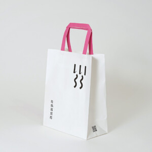 シンプルな縦留めのハンドルを採用した、食と雑貨のセレクトショップのオリジナル紙袋