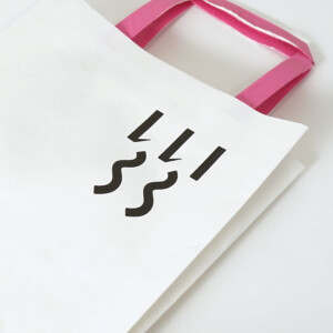シンプルな縦留めのハンドルを採用した、食と雑貨のセレクトショップのオリジナル紙袋