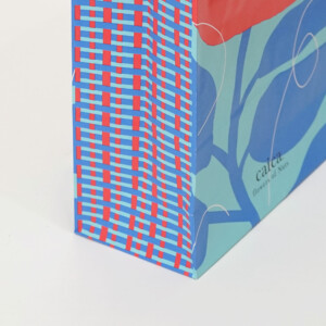 マチ部分にチェックデザインがフルカラー印刷された、人気スイーツブランドの華やかなオリジナル紙袋