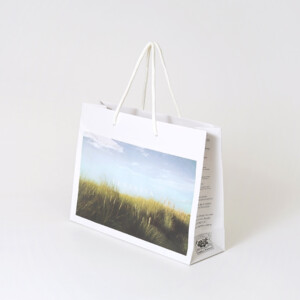 広大な草原がフルカラー印刷された、ファブリックブランドのオリジナル紙袋