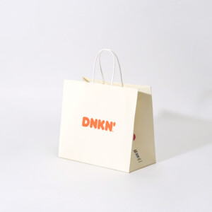 晒クラフト紙にポップなカラーリングとデザインが施された、有名ドーナツ&コーヒー専門店のオリジナル紙袋