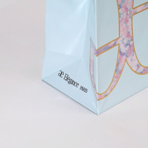 ゴールドの箔押し加工で装飾されたロゴマークが美しい、高級コスメブランドのオリジナル紙袋