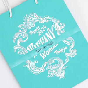 ターコイズブルーにシルバーの箔押し加工が映える、ハイジュエリーブランドの高級感あふれるオリジナル紙袋