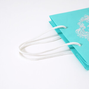 光沢感のあるパイレンロープのハンドルを使用した、ハイジュエリーブランドの高級感あふれるオリジナル紙袋