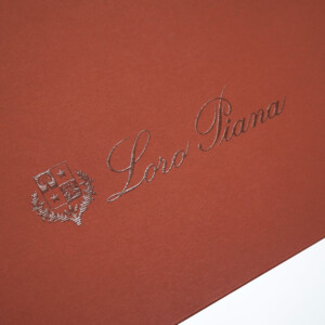 クラシカルな色合いの本体にエンボス加工と箔押しが施された、深い歴史のある服地のトップメーカーの高級感溢れるオリジナル紙袋