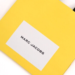 鮮やかなデイジーイエローにブラックの箔押しのロゴが映える、世界的有名ファッションブランドの「遊び心」が感じられる素敵なオリジナル紙袋