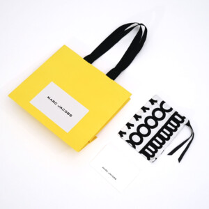 鮮やかなデイジーイエローにブラックの箔押しのロゴが映える、世界的有名ファッションブランドの「遊び心」が感じられる素敵なオリジナル紙袋