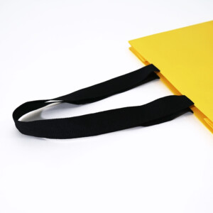 ハンドル部分は縦留め加工ですっきり上品な見た目の、世界的有名ファッションブランドのオリジナル紙袋