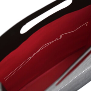 モノトーンの紙袋の内側に、鮮やかな赤色が印刷された有名コスメブランドの洗練された印象のオリジナル紙袋