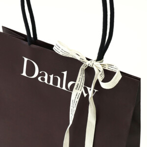 紙袋の正面に穴を開けない「縦留め」を採用した、スッキリと上品な印象の、東京発のフレグランスブランドのオリジナル紙袋