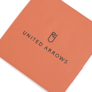 落ち着いたオレンジ色にブラックの箔押しのブランドロゴが映える、大人に向けたドレス軸のライフスタイルを提案するセレクトショップのオリジナル紙袋