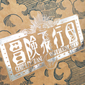 シルバーの箔押しが目を引く、クラフト紙本来の色味を活かしたジブリパークのグッズショップ「冒険飛行団」のレトロなオリジナル紙袋 
