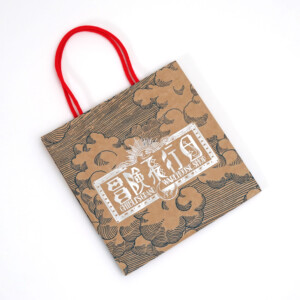 シルバーの箔押しが目を引く、クラフト紙本来の色味を活かしたジブリパークのグッズショップ「冒険飛行団」のレトロなオリジナル紙袋 