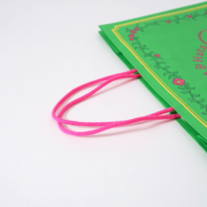 ポップなカラーのハンドルがかわいい、フルカラー印刷でレトロな花と可愛らしい帽子が表現された、ジブリパークのグッズショップ「ハッター帽子店」のオリジナル紙袋 