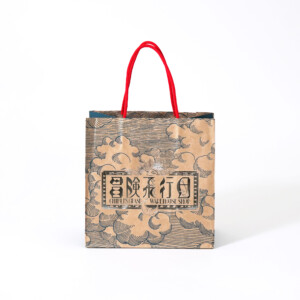 ポップなカラーのハンドルがかわいい、クラフト紙本来の色味を活かしたジブリパークのグッズショップ「冒険飛行団」のレトロなオリジナル紙袋