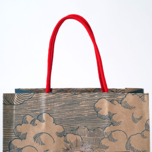 ポップなカラーのハンドルがかわいい、クラフト紙本来の色味を活かしたジブリパークのグッズショップ「冒険飛行団」のレトロなオリジナル紙袋