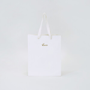 純白のボディに金の箔押しロゴが輝く、ブライダル企業の洗練されたオリジナル紙袋