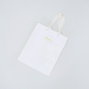 純白のボディに金の箔押しロゴが輝く、ブライダル企業の洗練されたオリジナル紙袋