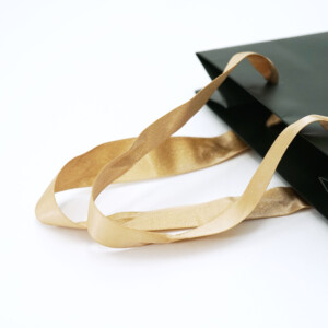 美しさを追求するセレクトコスメショップが贈る、ゴールドのラメリボンが使われた、ブランド10周年を記念するホリデー限定オリジナル紙袋