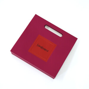 斬新なデザインで有名なラグジュアリーブランドの、多層的なロゴ加工が施された高級感のあるオリジナル紙袋