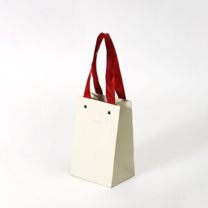 コットンホワイトに赤リボンが映える、エンボス加工が美しいジュエリーブランドの特別感あふれるオリジナル紙袋